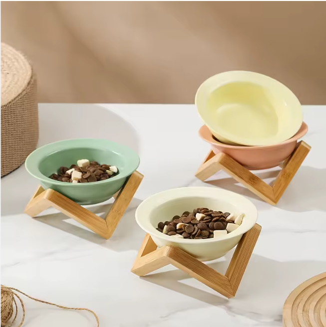 Omertà ceramic cat bowl with bamboo stand, tilted design.