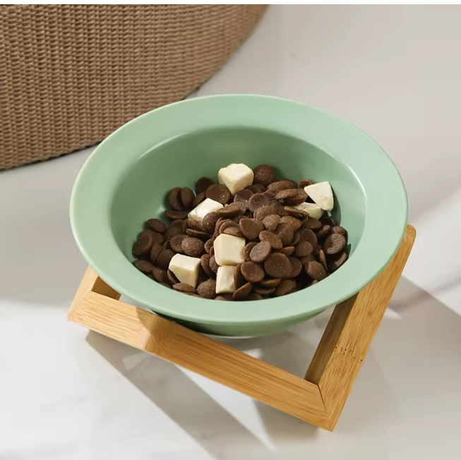 Omertà ceramic cat bowl with bamboo stand, tilted design.