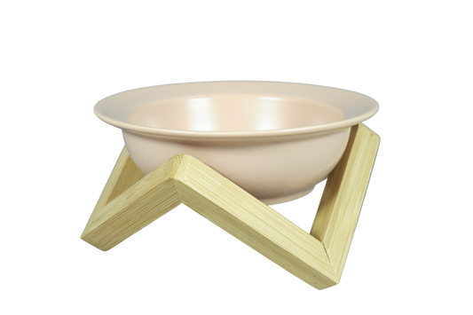 Pink elevated ceramic cat bowl on bamboo stand.